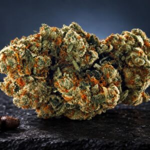 Flores secas de cannabis con tricomas cristalinos y pistilos naranjas, junto a semillas de café sobre superficie negra